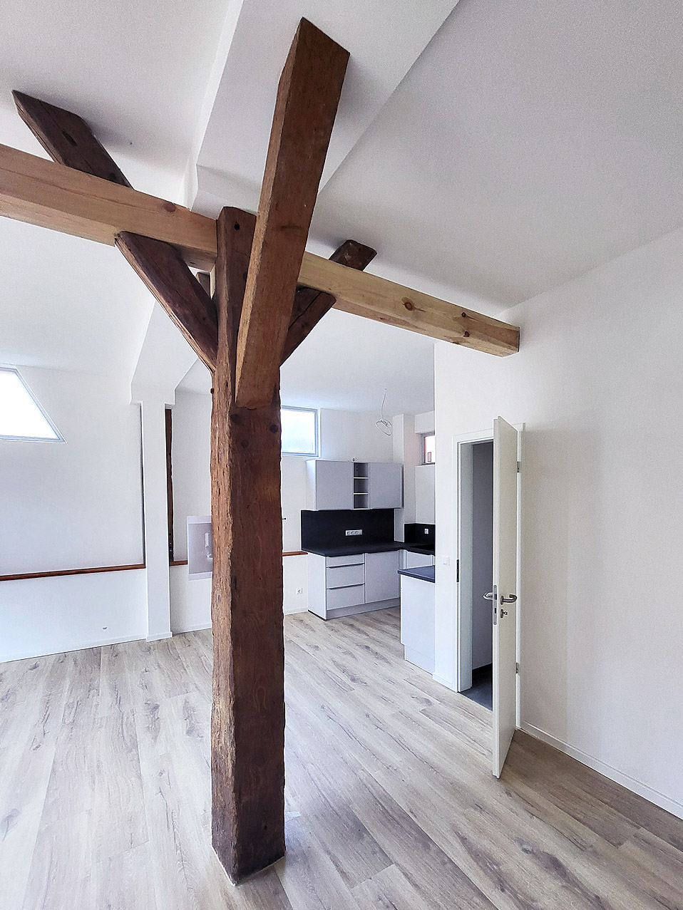 Gipskartondecke mit sichtbaren Holzbalken im Dachgeschoss