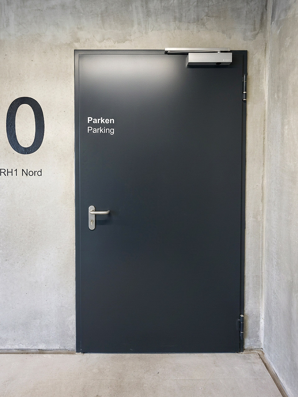 Graue Stahlblechtür in einer Tiefgarage