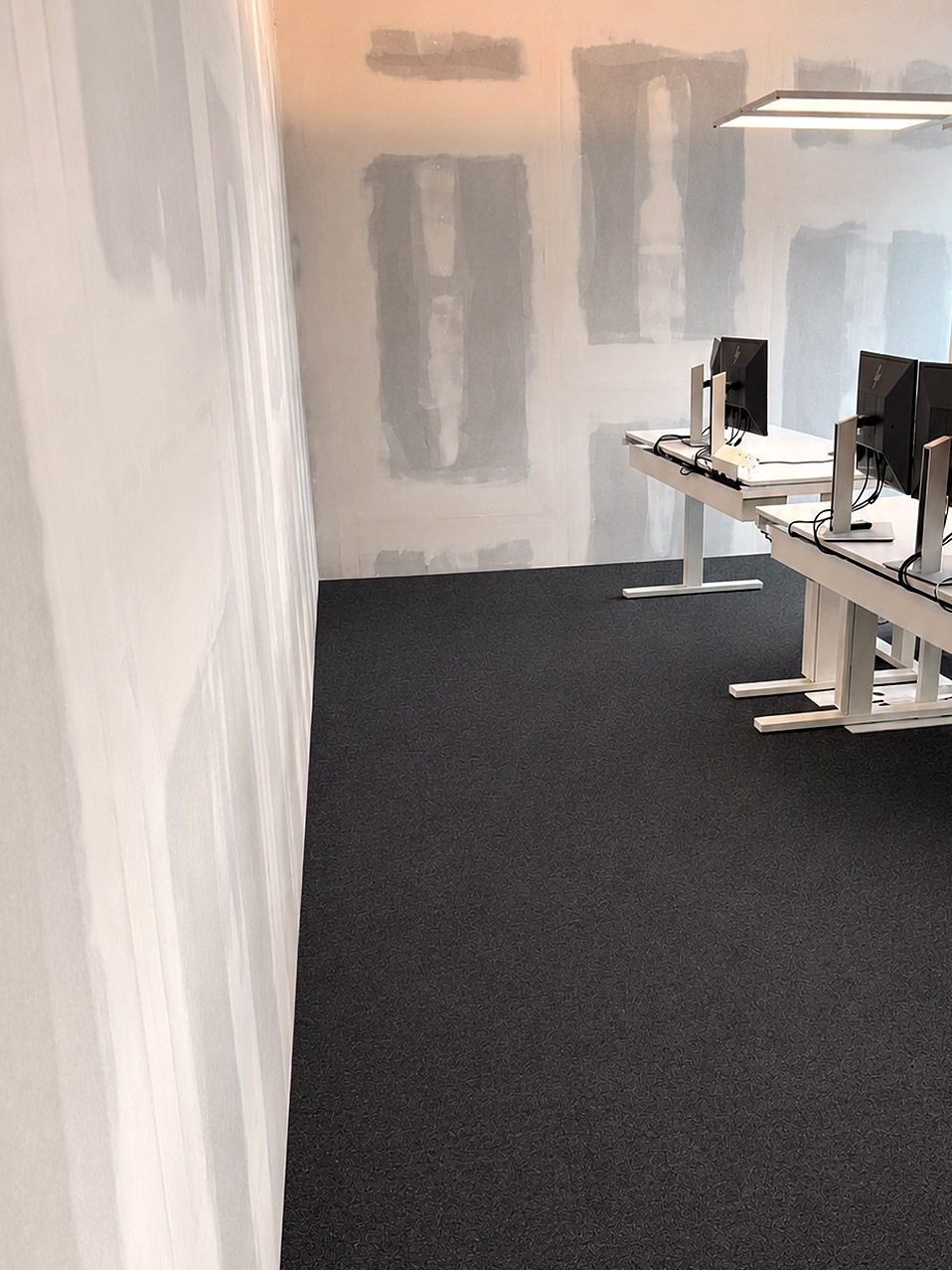 Schallschutzwand im Bau mit Blick in ein fertiges Büro