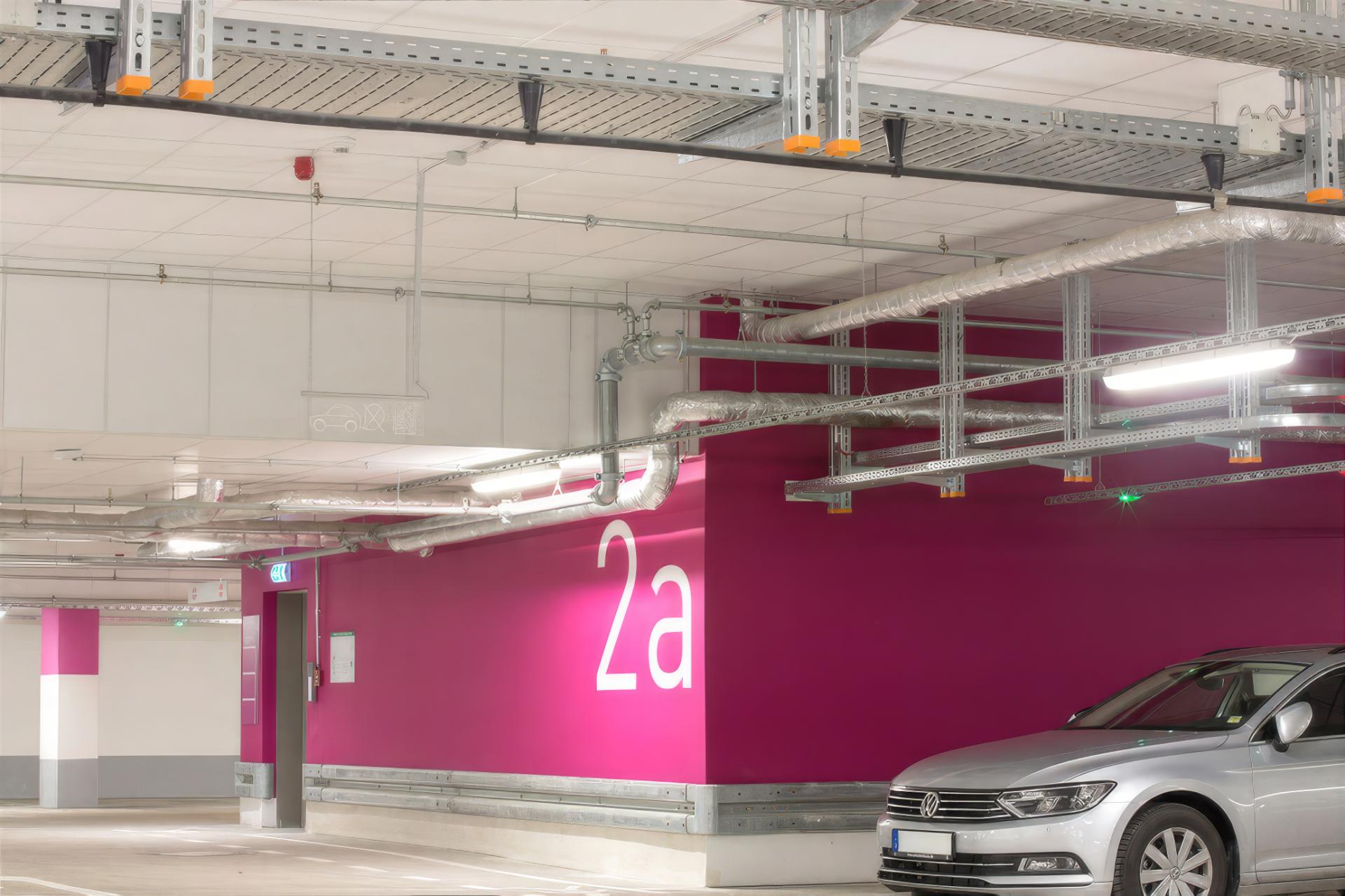 Magenta gestaltete Wand in der Tiefgarage NeuerMarkt