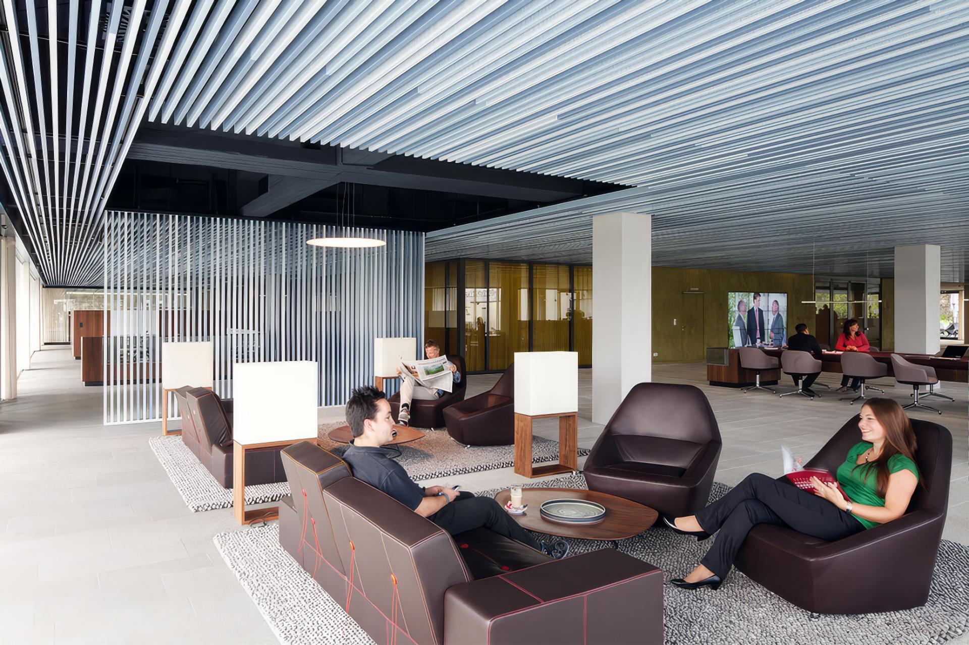Lounge mit Metalllamellendecke in der REHAU-Hauptverwaltung
